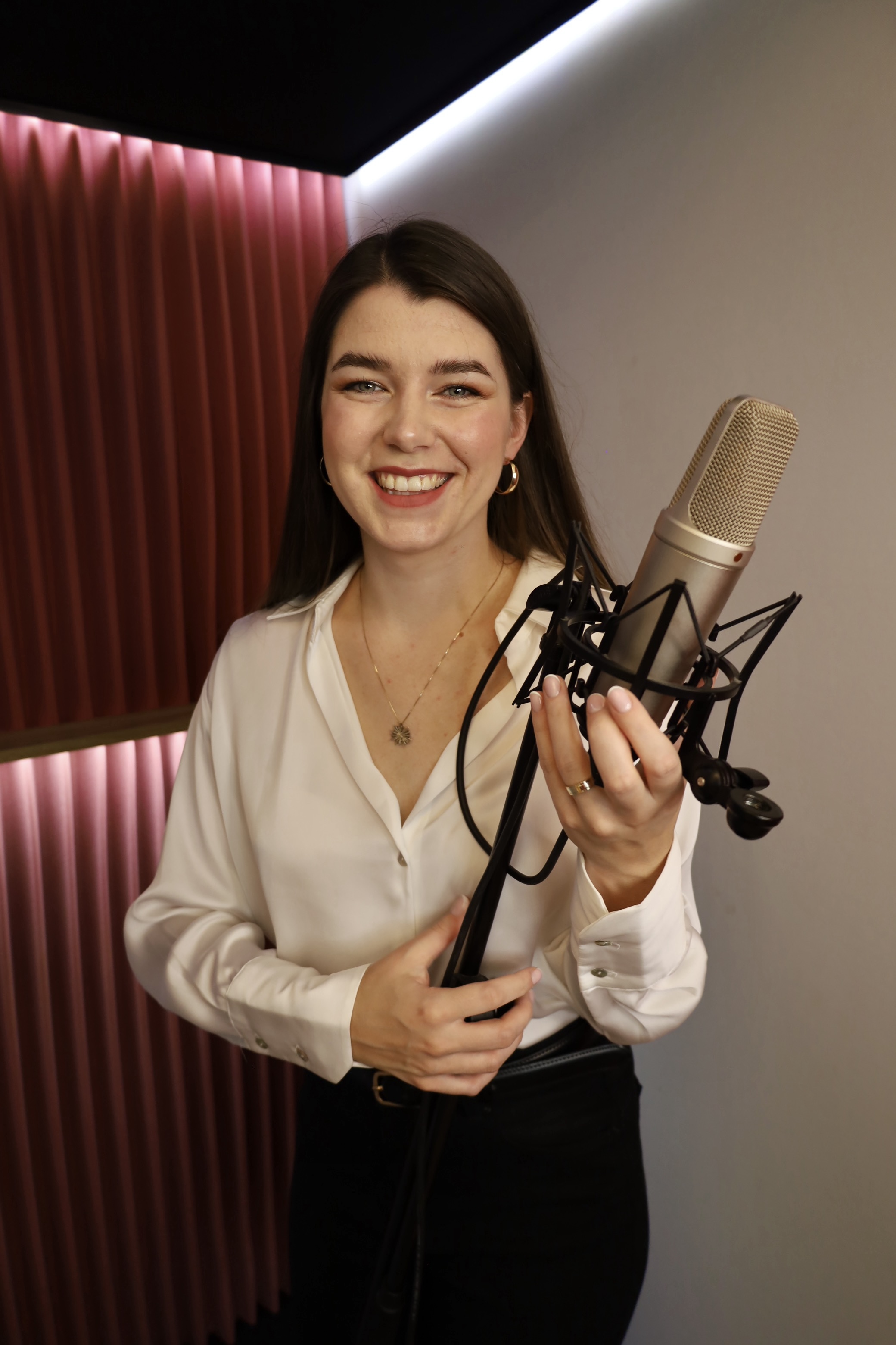 Diana Kuls z mikrofonem studyjnym w kabinie nagraniowej